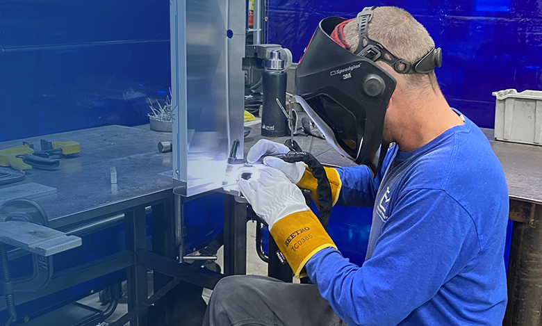 person welding espresso machine together